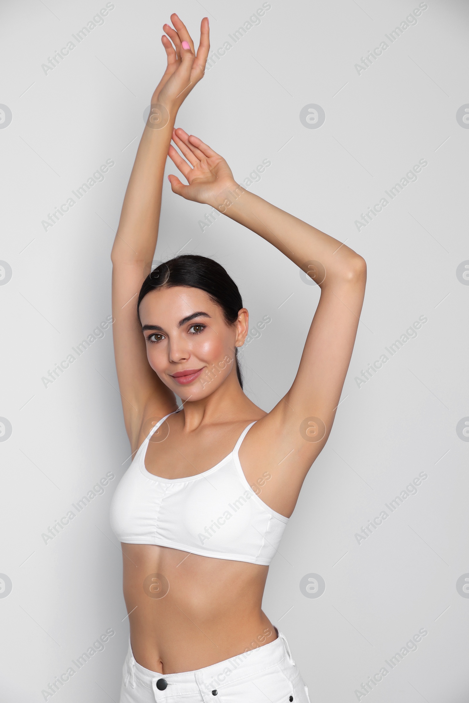 Photo of Young woman showing smooth skin after epilation on white background