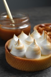 Photo of Tartlet with meringue on table, closeup. Delicious dessert