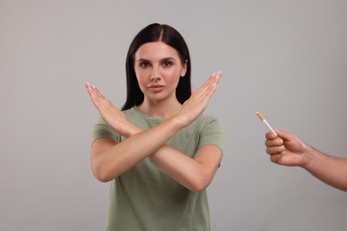 Photo of Stop smoking concept. Woman refusing cigarette on grey background