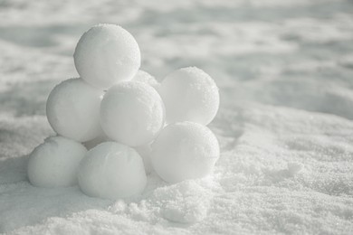 Photo of Perfect round snowballs on snow outdoors, closeup. Space for text