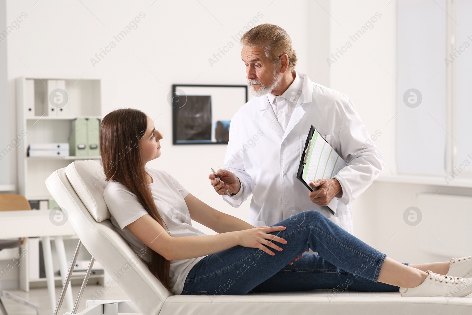 Photo of Doctor with medical card consulting patient in clinic