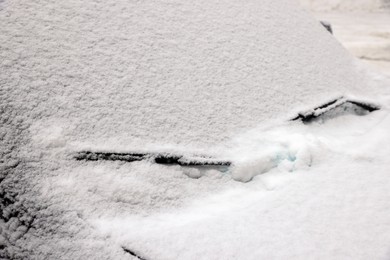Photo of Car with windscreen wipers covered with snow outdoors on winter day