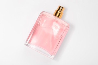 Photo of Pink women's perfume in bottle on white background, top view