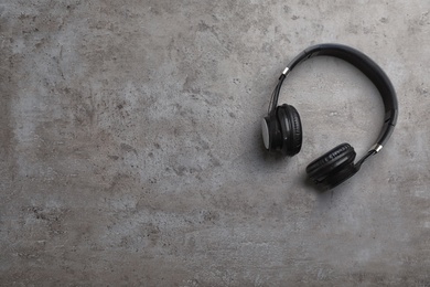 Photo of Stylish modern headphones and space for text on gray background, top view