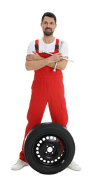 Photo of Full length portrait of professional auto mechanic with wheel and lug wrench on white background