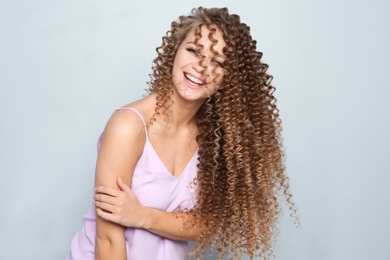 Photo of Portrait of beautiful young woman with shiny wavy hair on color background