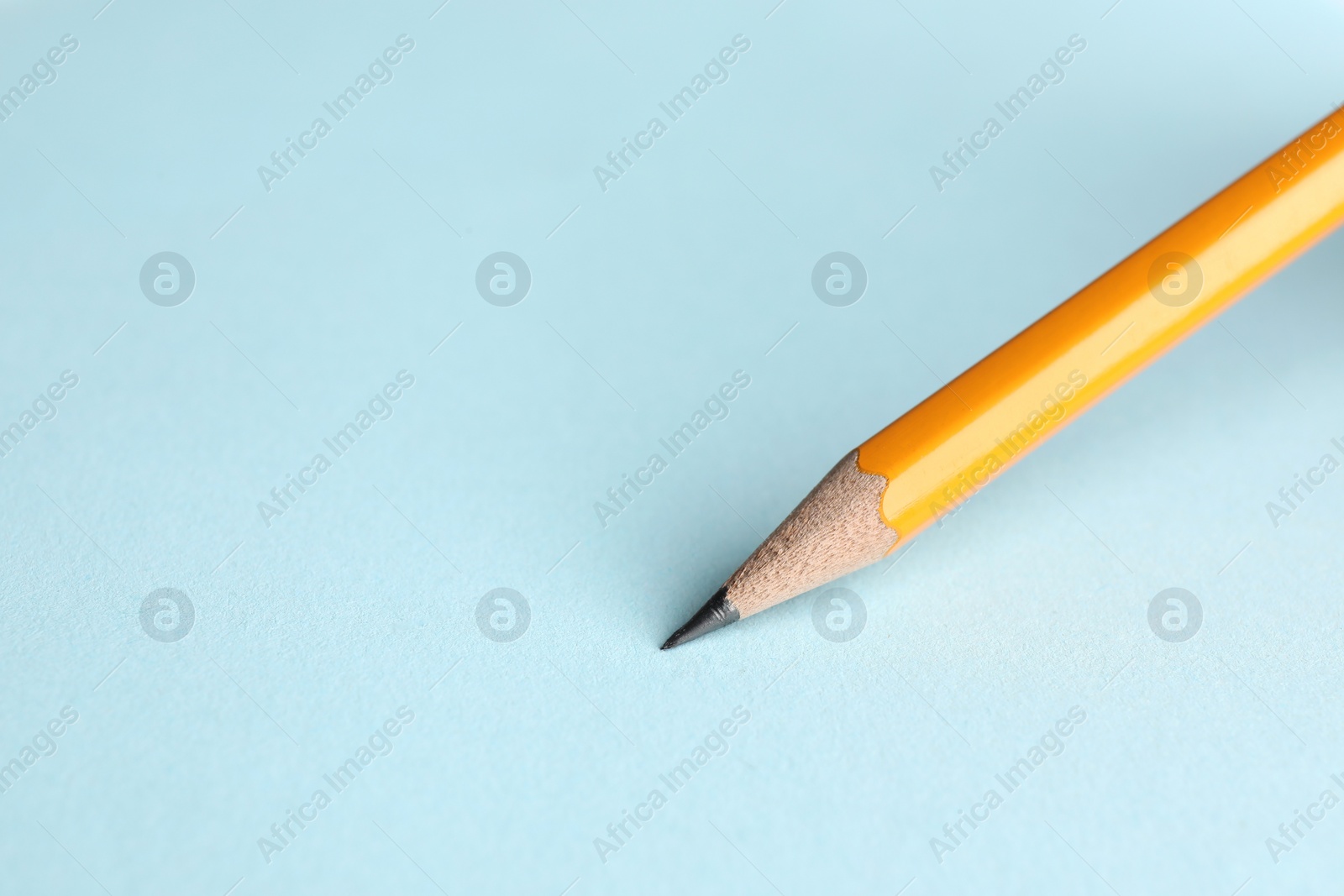 Photo of Drawing with sharp graphite pencil on light blue background, closeup. Space for text