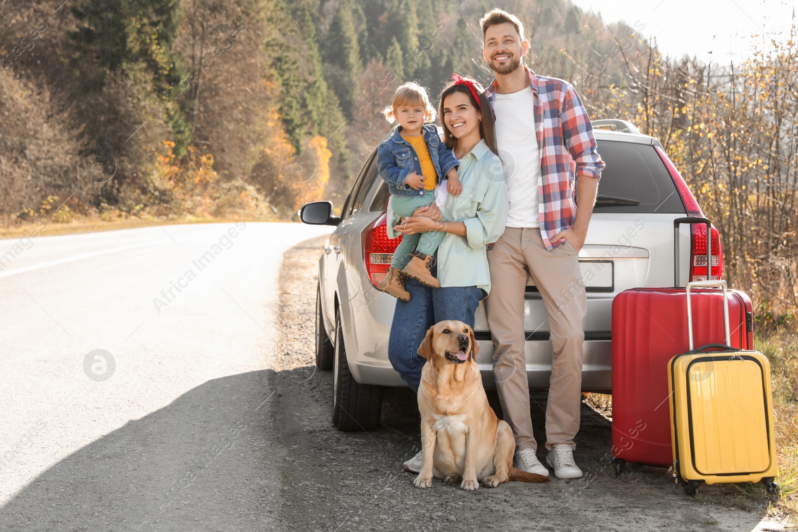 Photo of Parents, their daughter and dog near car outdoors, space for text. Family traveling with pet