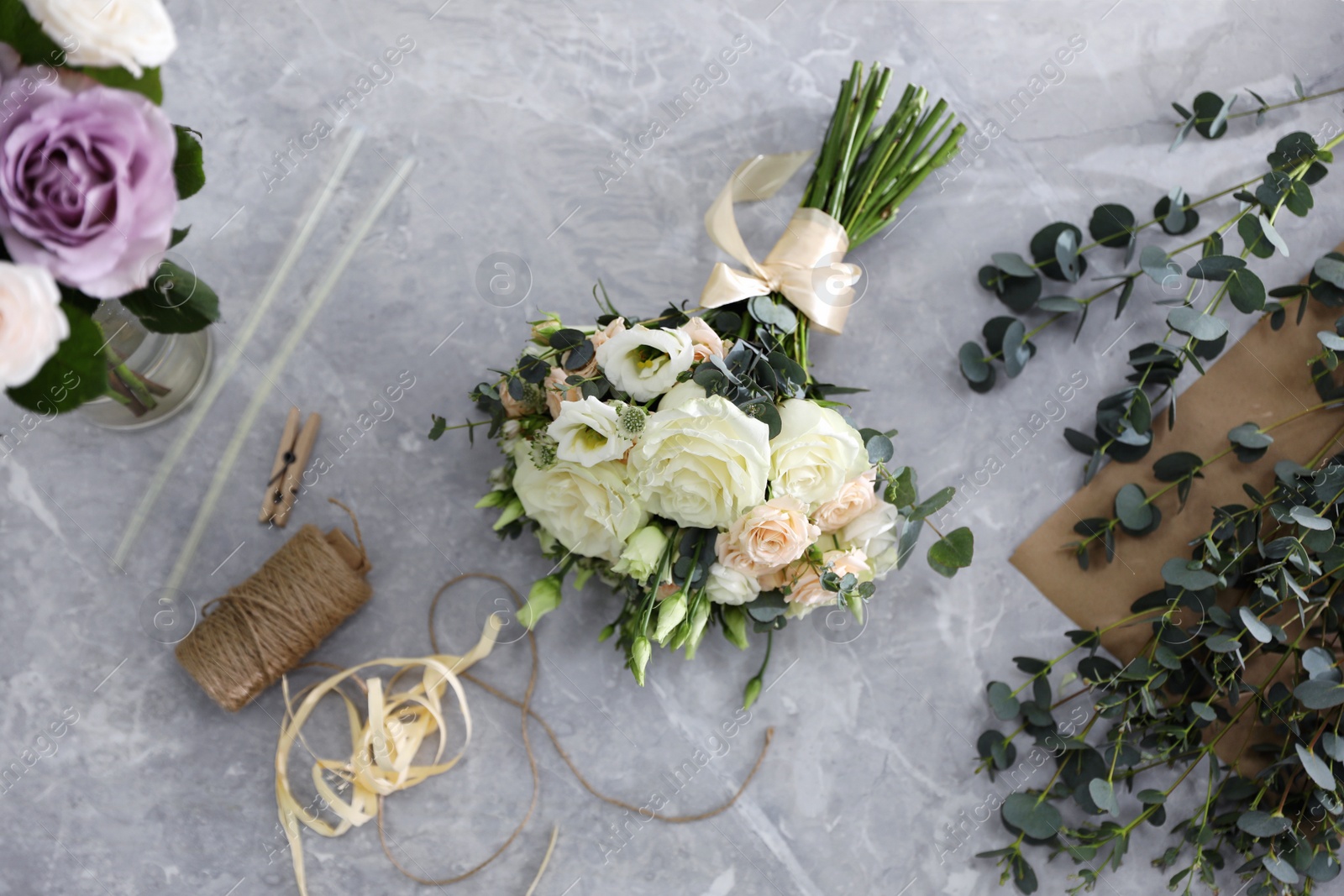 Photo of Beautiful wedding bouquet on light grey marble table, flat lay