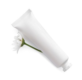 Photo of Tube of hand cream and chamomile on white background, top view