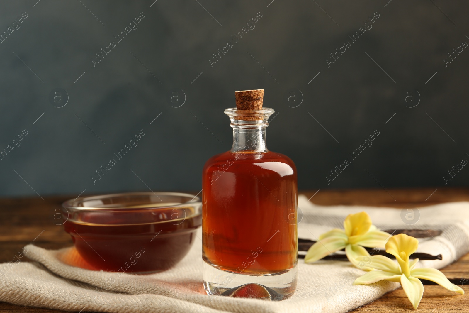 Photo of Aromatic homemade vanilla extract on wooden table