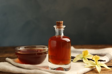 Aromatic homemade vanilla extract on wooden table