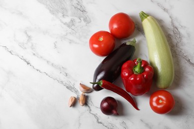 Fresh vegetables for ratatouille on white marble table, flat lay. Space for text