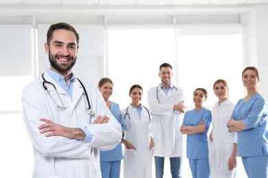 Photo of Male medical doctor with colleagues in clinic. Unity concept