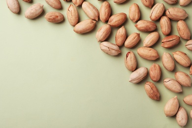 Photo of Composition with ripe pecan nuts on color background, flat lay. Space for text