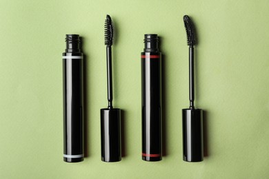 Different mascaras for eyelashes on light background, flat lay. Makeup product