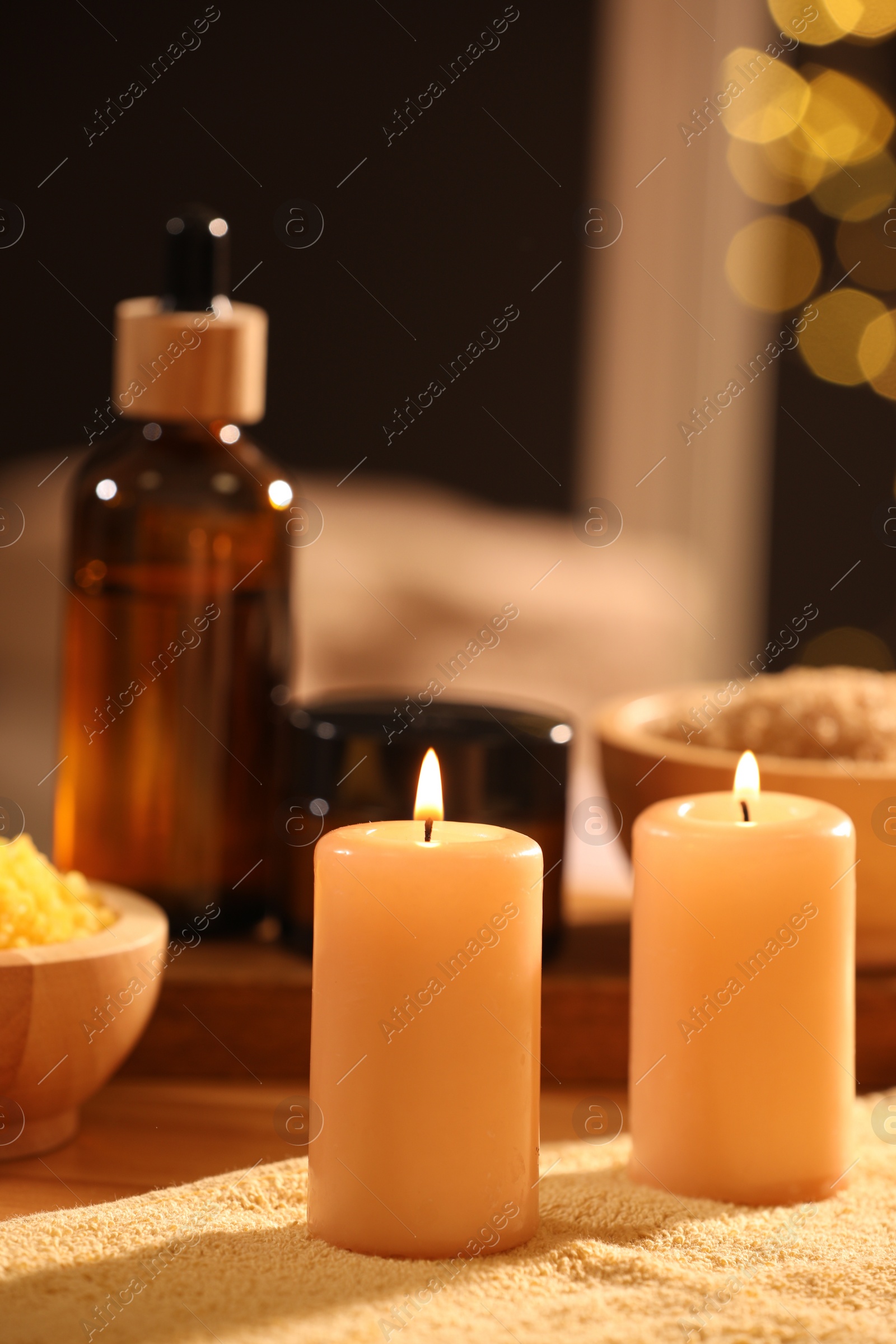 Photo of Spa composition with burning candles and personal care products on soft light surface, closeup