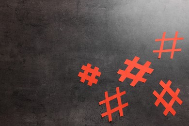 Red paper cutout symbols of hashtag on dark background, flat lay. Space for text