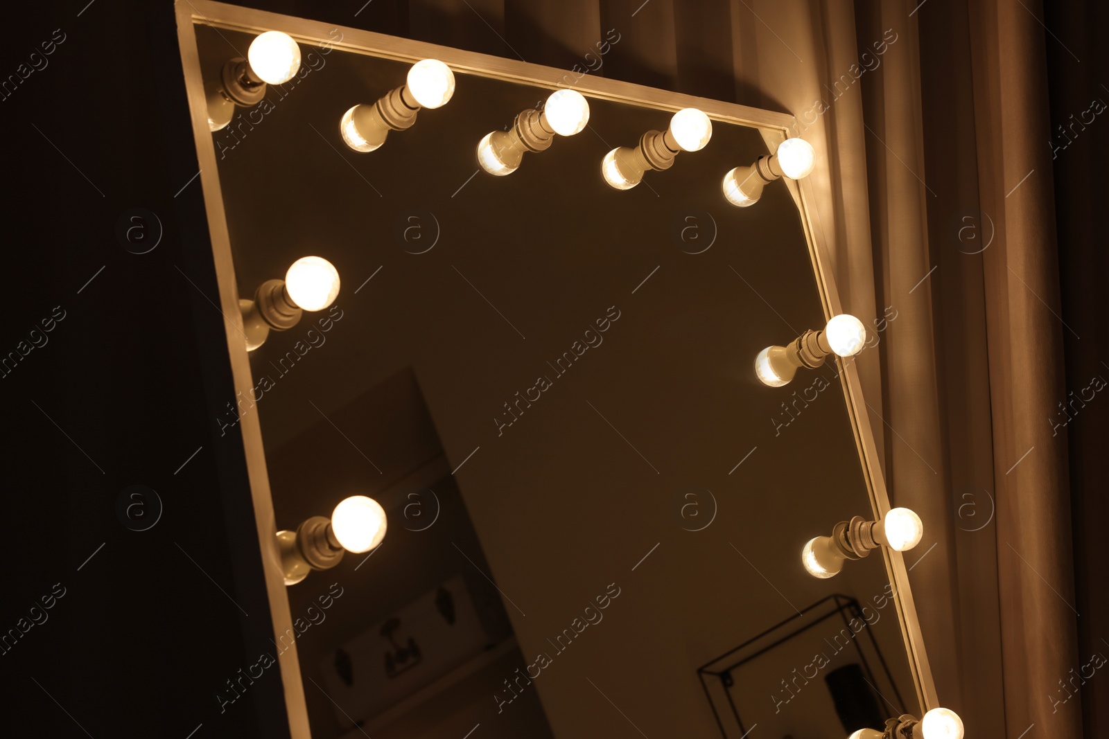 Photo of Beautiful mirror with light bulbs in makeup room, closeup