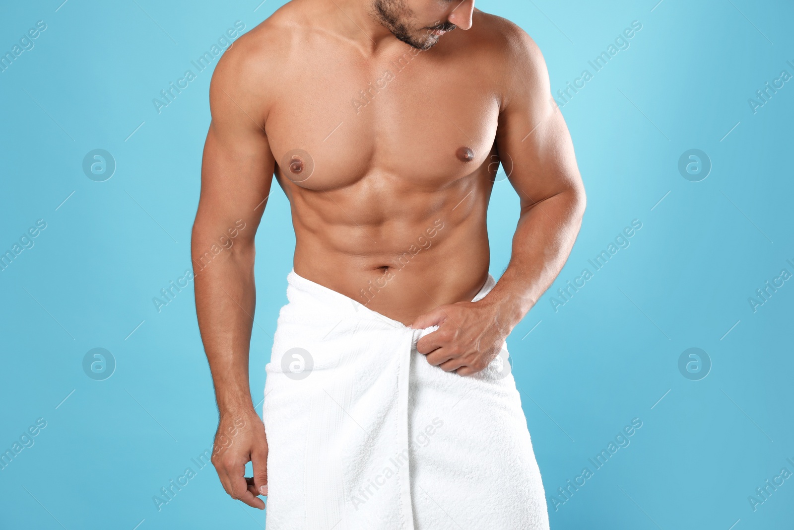 Photo of Young man with slim body on light blue background, closeup view