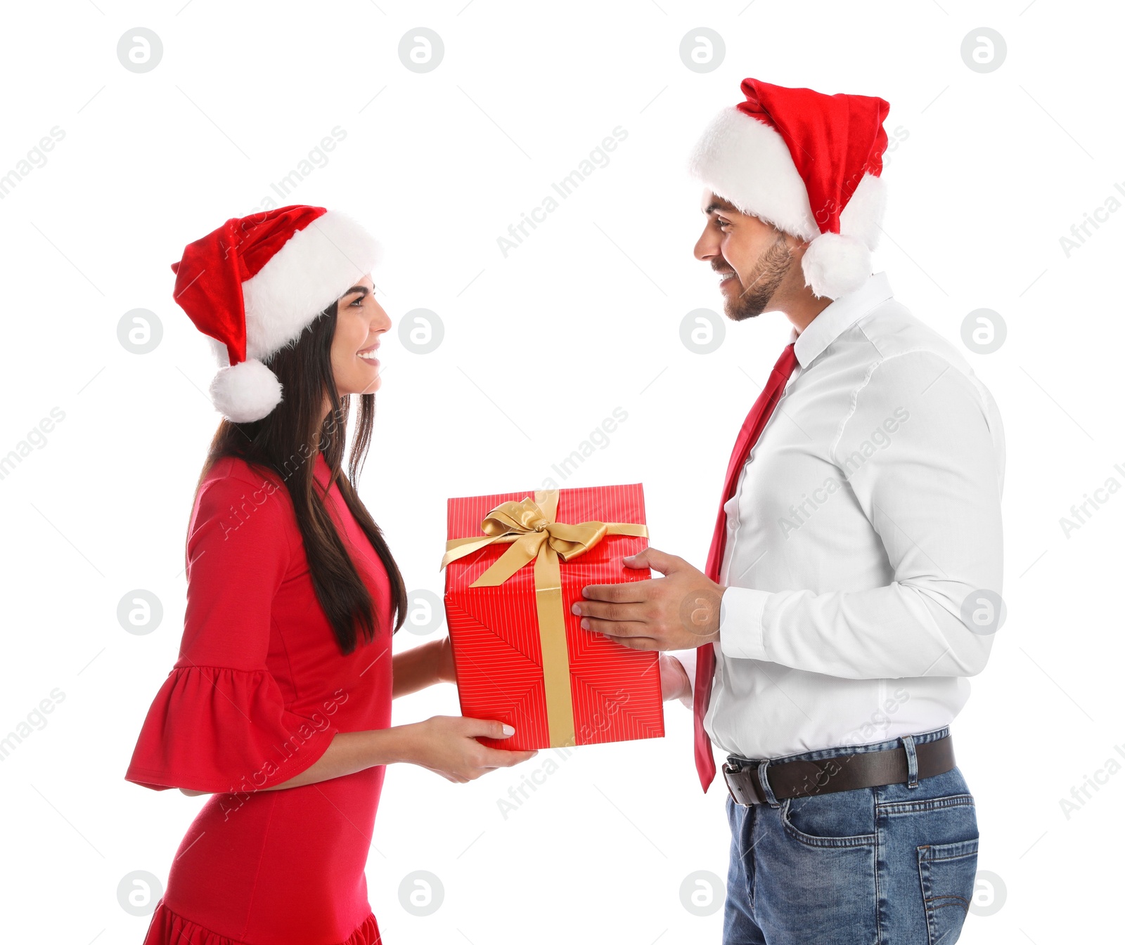 Photo of Lovely young couple in Santa hats with gift box on white background. Christmas celebration