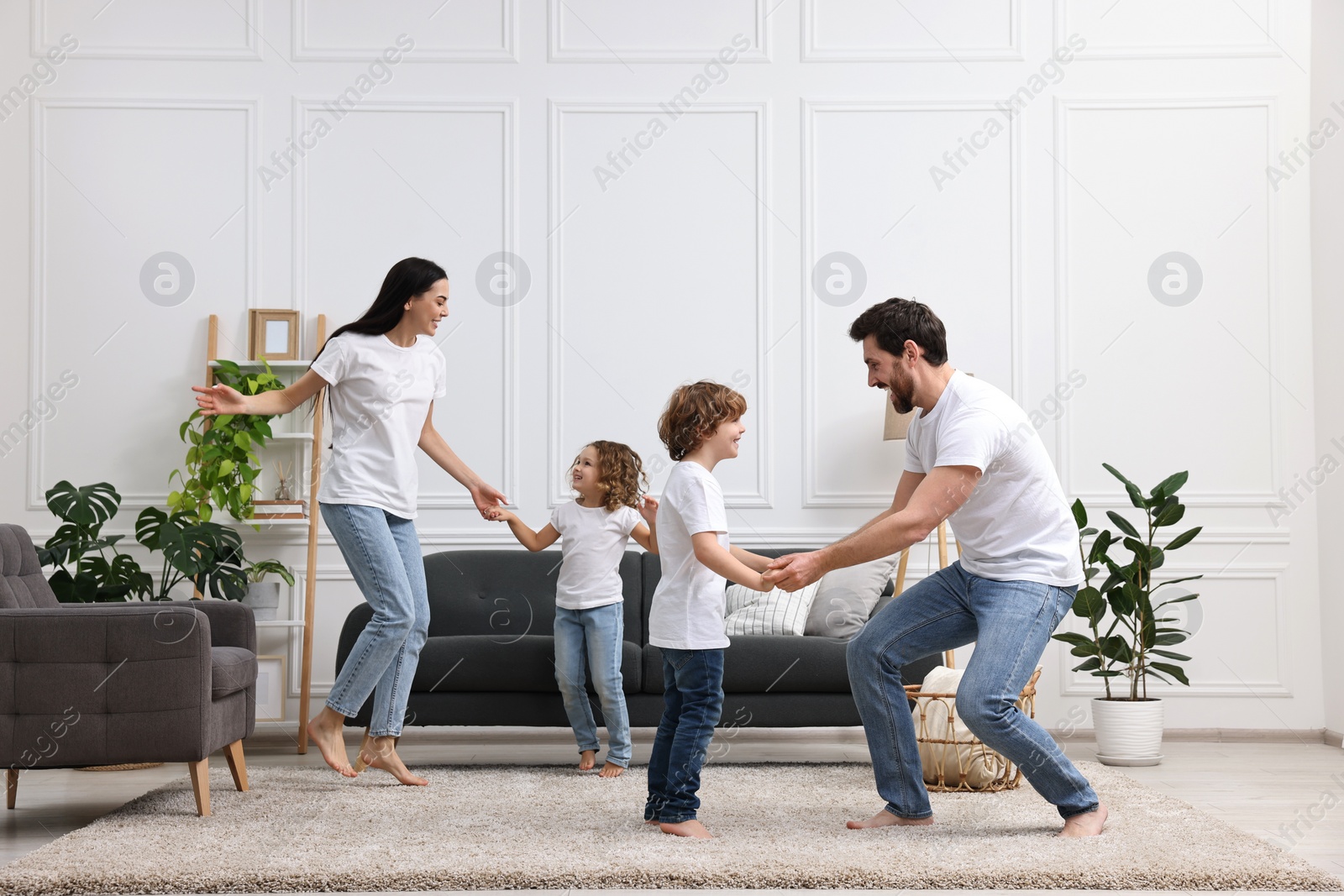 Photo of Happy family dancing and having fun in living room