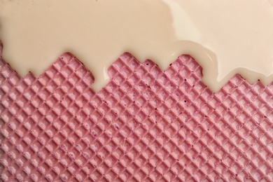 Hot white chocolate on wafer, closeup. Crispy food