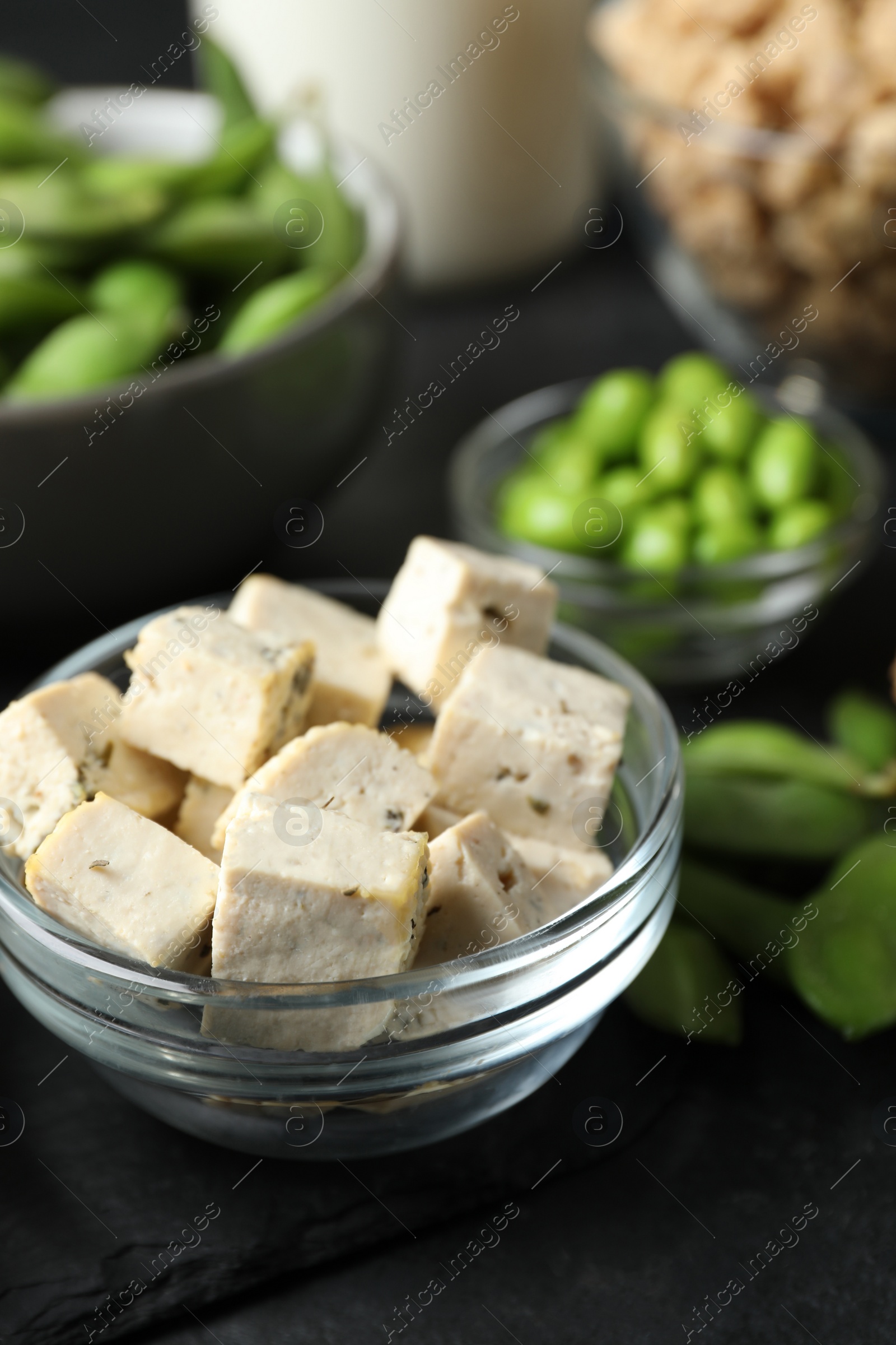 Photo of Delicious tofu and other organic soy products on black table, closeup