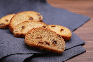 Photo of Sweet hard chuck crackers with raisins on wooden table, closeup