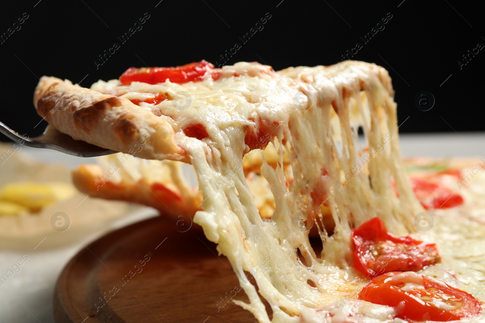 Photo of Taking slice of delicious pizza Margherita at table, closeup