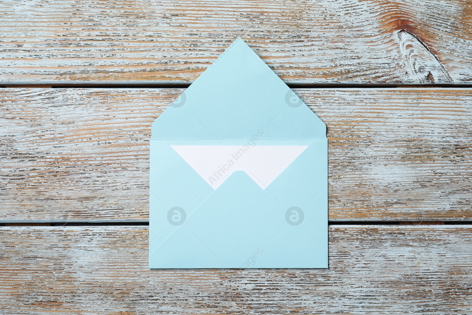 Photo of Letter envelope with card on wooden rustic table, top view