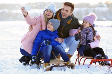 Photo of Happy family taking selfie outdoors on winter day