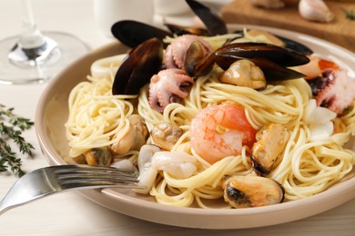 Delicious pasta with sea food on white wooden table, closeup