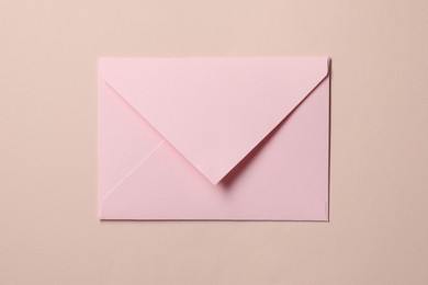 Photo of Letter envelope on beige background, top view