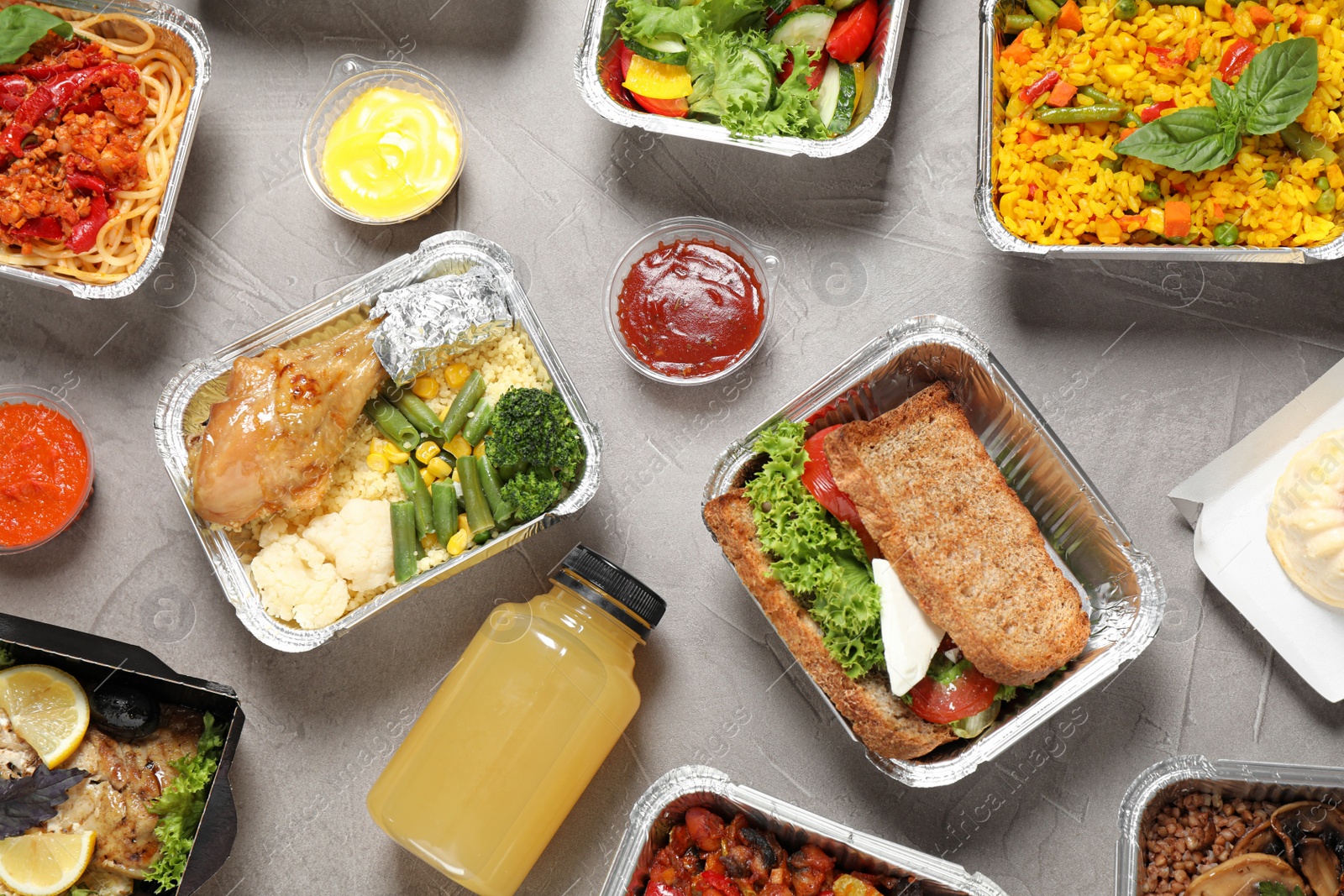 Photo of Lunchboxes on grey table, flat lay. Healthy food delivery