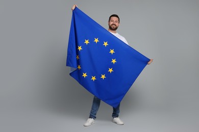 Man holding European Union flag on light grey background