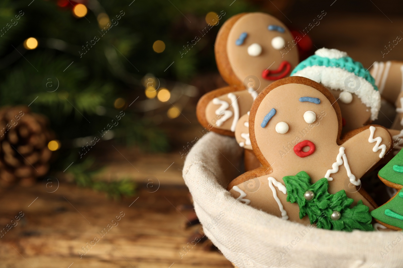 Photo of Delicious homemade Christmas cookies in bowl against blurred festive lights, closeup. Space for text