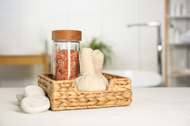 Photo of Composition with spa herbal bags on white wooden table in bathroom. Space for text