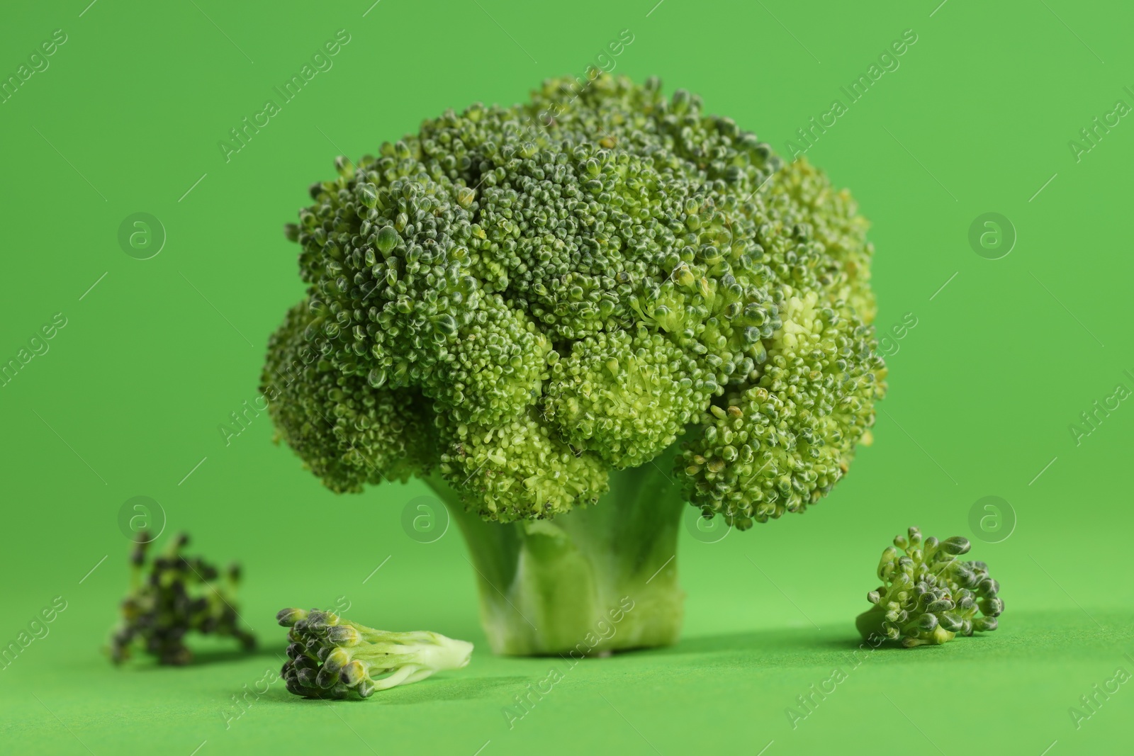 Photo of Fresh raw broccoli on light green background