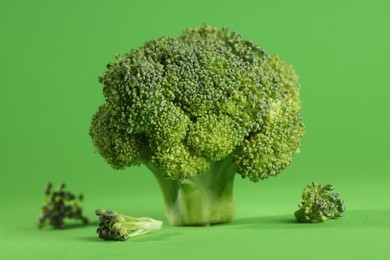 Fresh raw broccoli on light green background