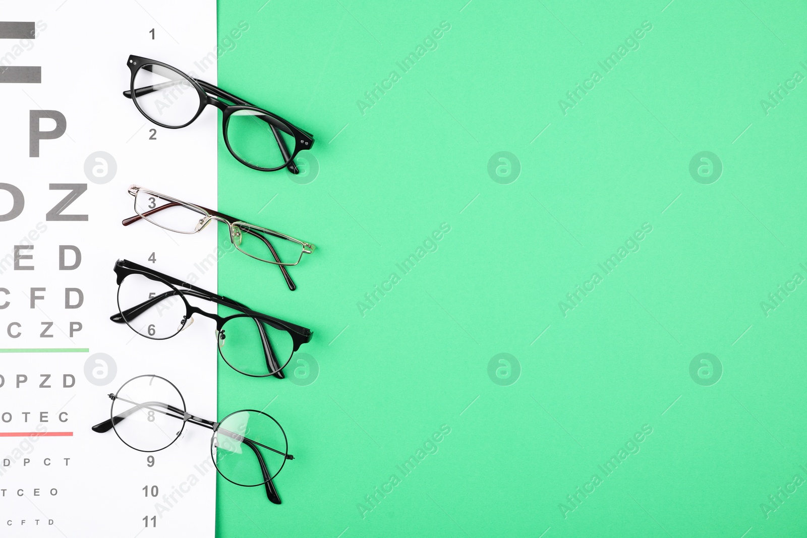 Photo of Vision test chart and glasses on green background, flat lay. Space for text