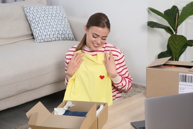 Photo of Happy woman unpacking parcels at home. Online store
