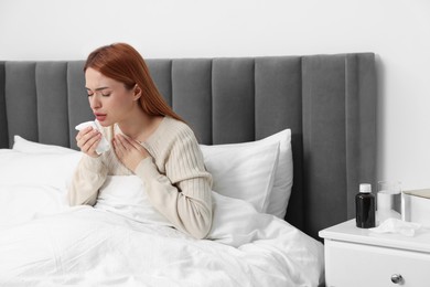 Photo of Woman with tissue coughing at home. Cold symptoms