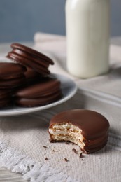 Tasty choco pies and milk on white wooden table