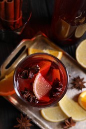 Photo of Glass of aromatic punch drink and ingredients on table, flat lay