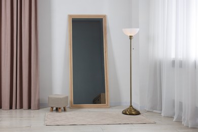 Photo of Stylish makeup room interior with long mirror and lamp