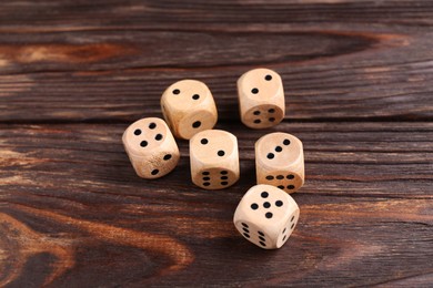 Photo of Many dices on wooden table. Game cubes