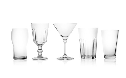 Set of empty glasses for different drinks on white background