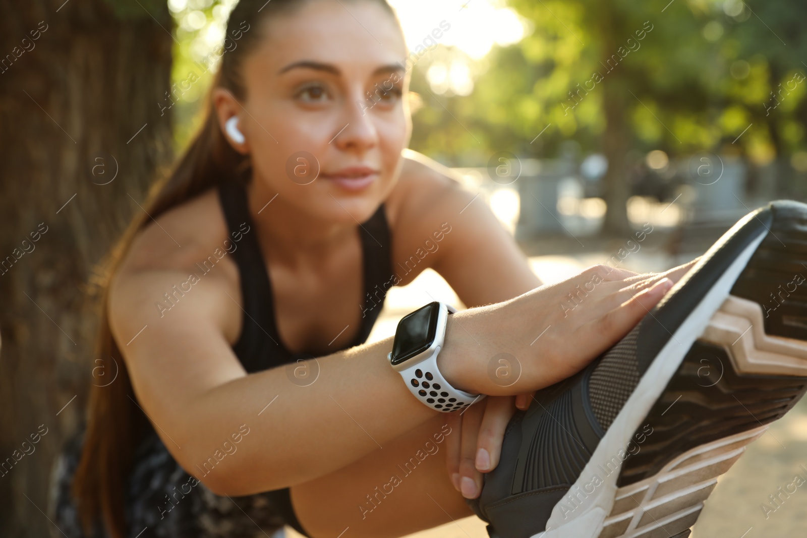 Photo of Woman wearing modern smart watch during training outdoors, focus on hand