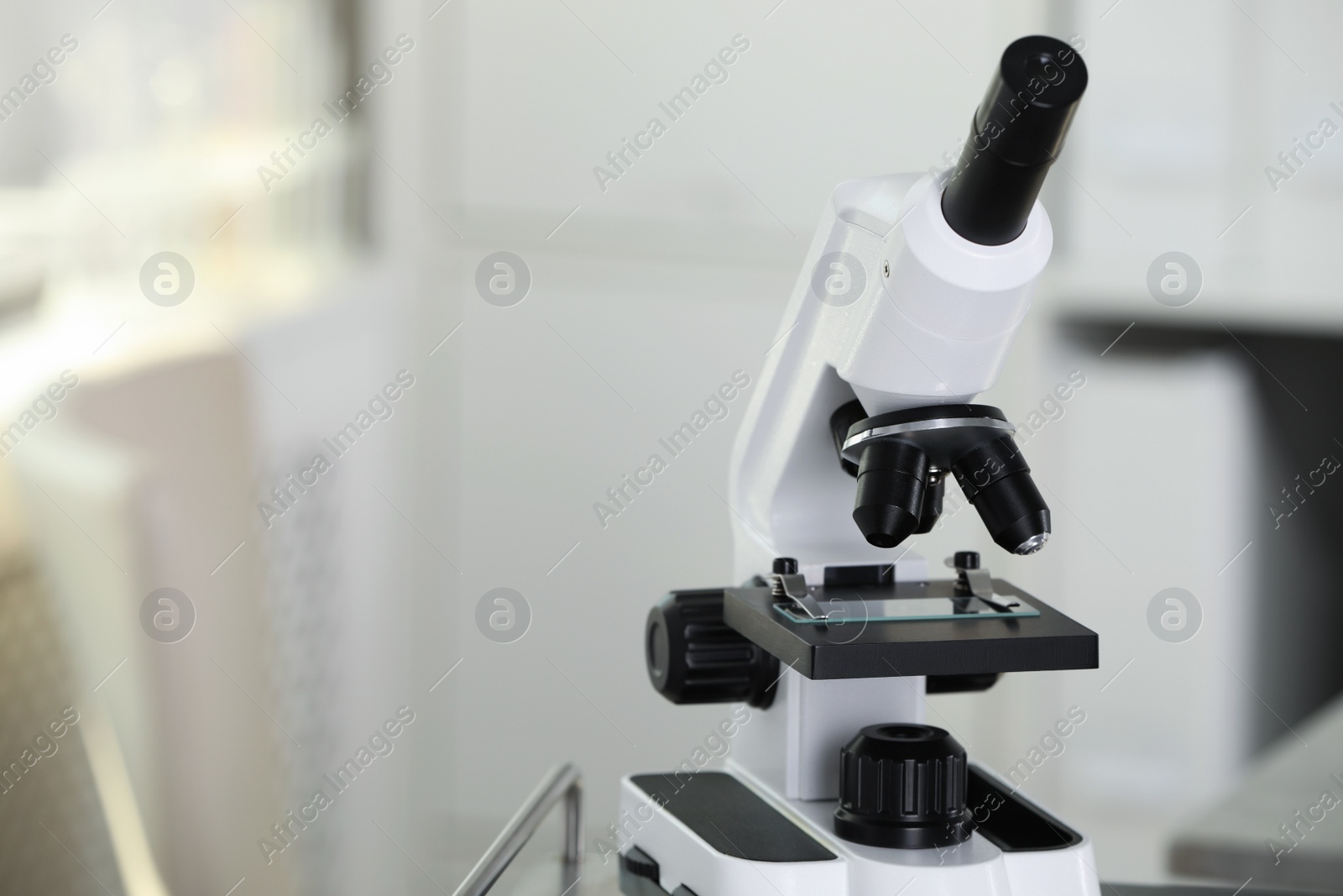Photo of Modern medical microscope on blurred background, closeup with space for text. Laboratory equipment